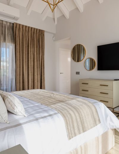 After: bedroom with TV and beams