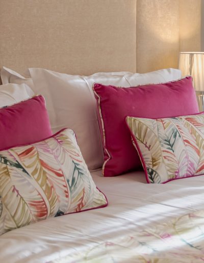 After: styled bed with pink cushions