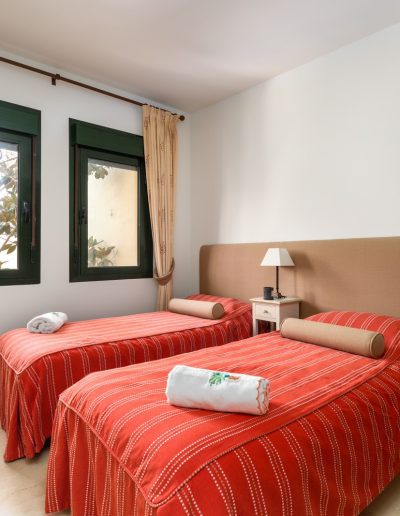 Before: twin bedroom with red bedding